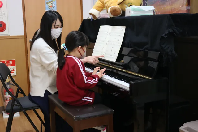 先生とピアノを弾く園児