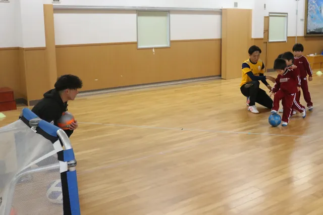 ホールでボールを追いかける園児たち