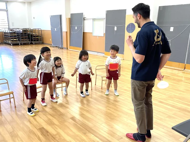 体操教室で先生の話を聞く園児たち